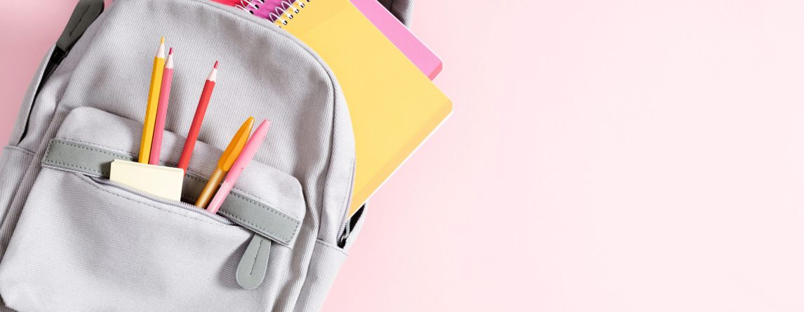 Back to school concept. Backpack with school supplies, pens, pencils, notebook on pastel pink background. Flat lay, top view, copy space Back to school concept. Backpack with school supplies, pens, pencils, notebook on pastel pink background. Flat lay, top view, copy space